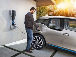 home car charging picture. A man is charging his electric car. Car is silver cover.